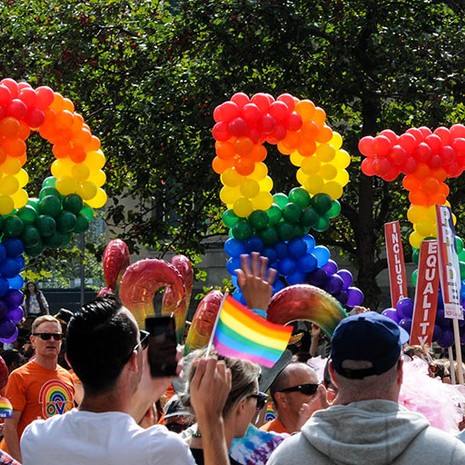 Image of a crowd celebrating at a pride parade on a sunny day